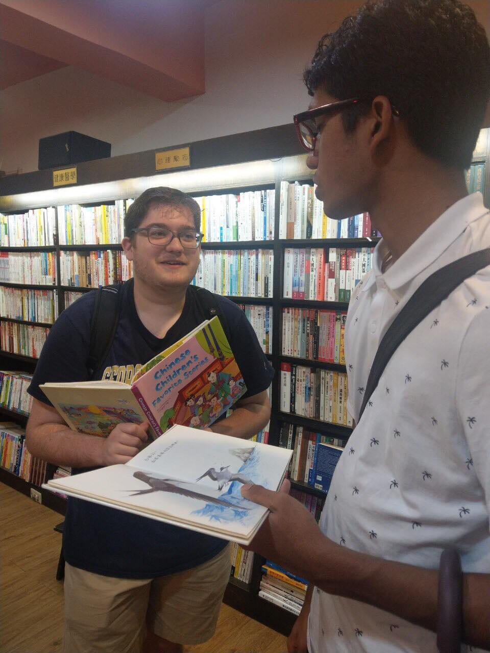 Author taking to another student with a book in hand 
