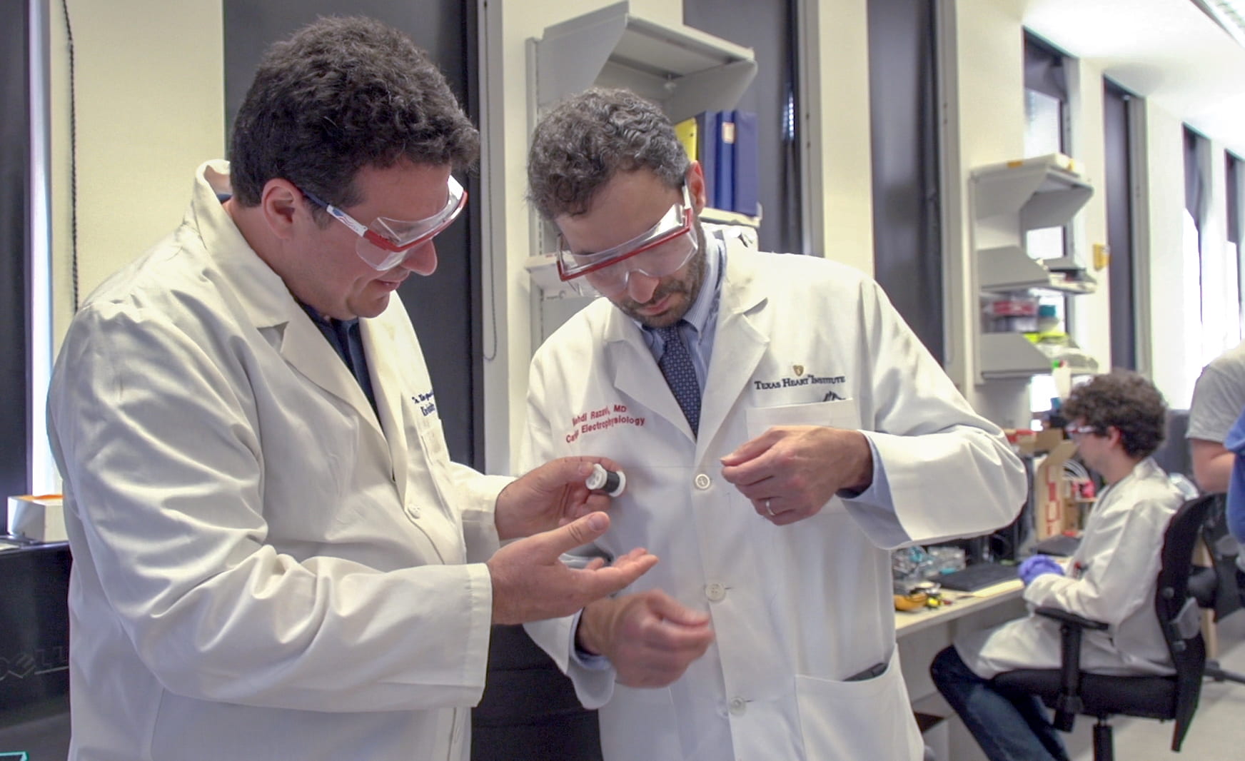 Rice University Professor Matteo Pasquali, left, and Dr. Mehdi Razavi of the Texas Heart Institute check a thread of carbon nanotube fiber invented in Pasquali's Rice lab. They are collaborating on a method to use the fibers as electrical bridges to restore conductivity to damaged hearts. (Credit: Texas Heart Institute)